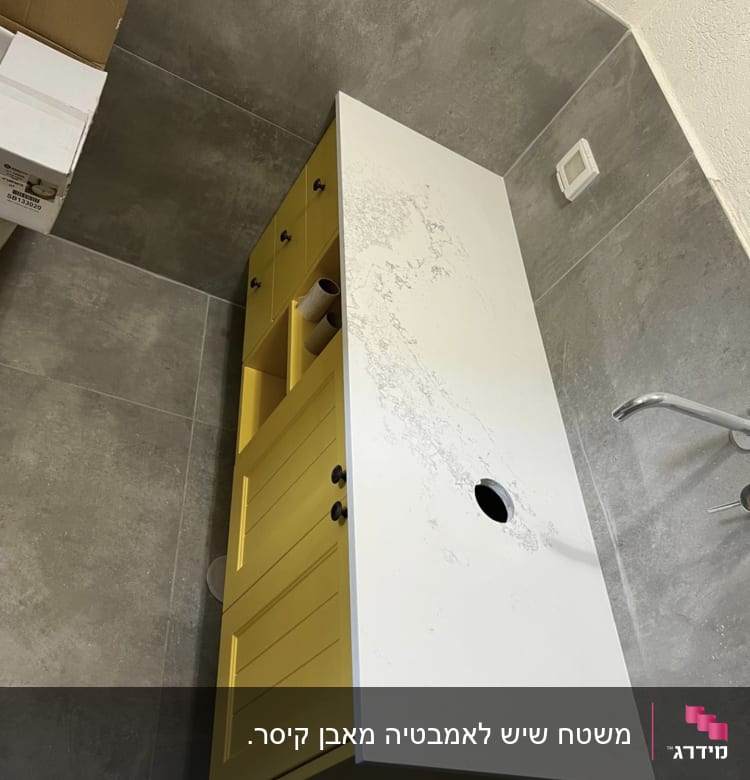 שיש לבן עם דוגמת עורקים אפורה על ארון צהוב